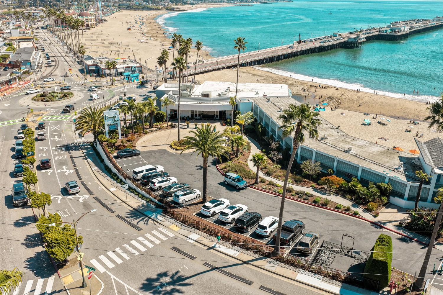 Aerial view of hospitality property with parking areas and maintained landscape by K&D Landscaping