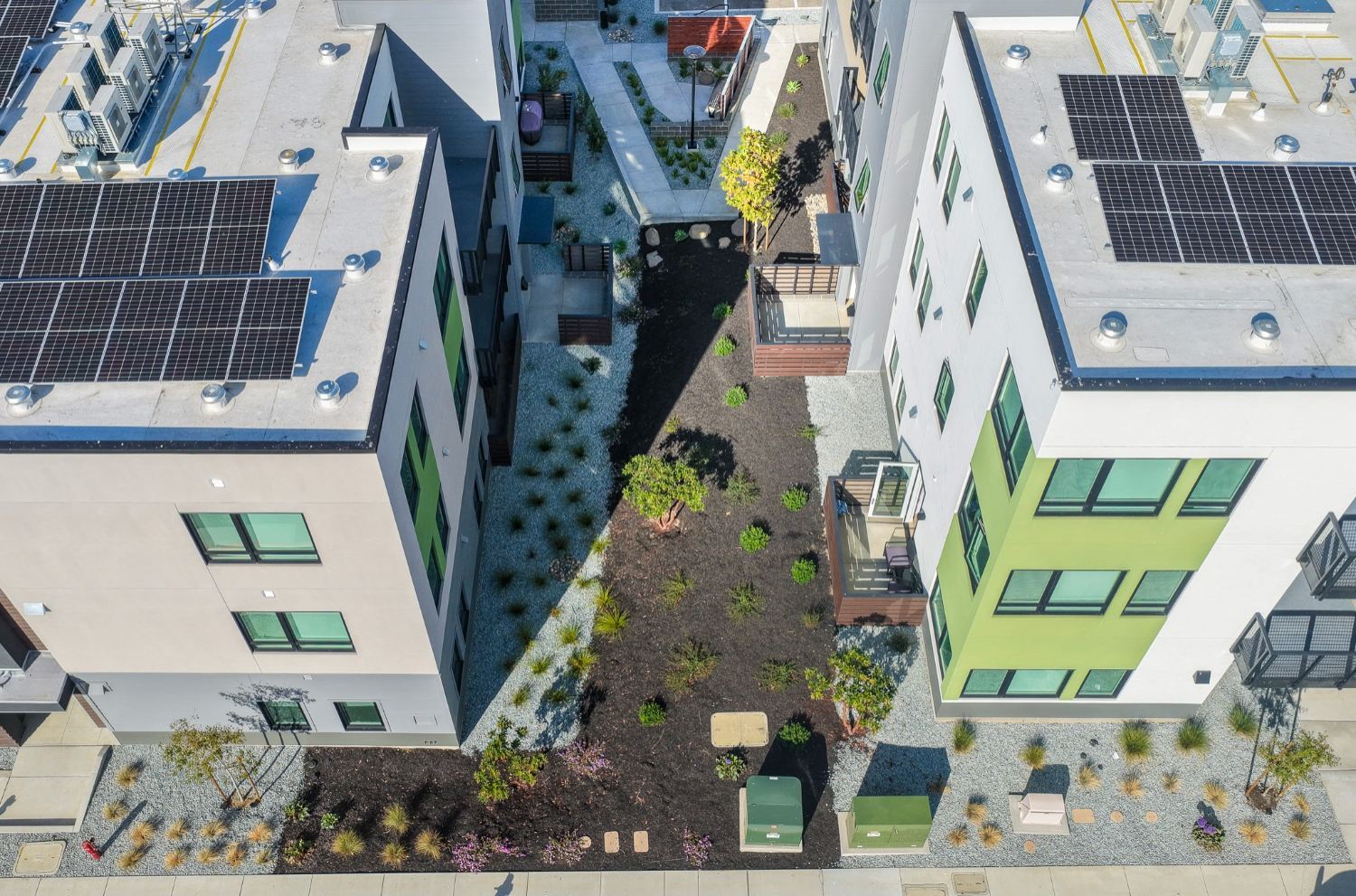 Apartment walkway lined with professionally installed landscape beds by K&D Landscaping