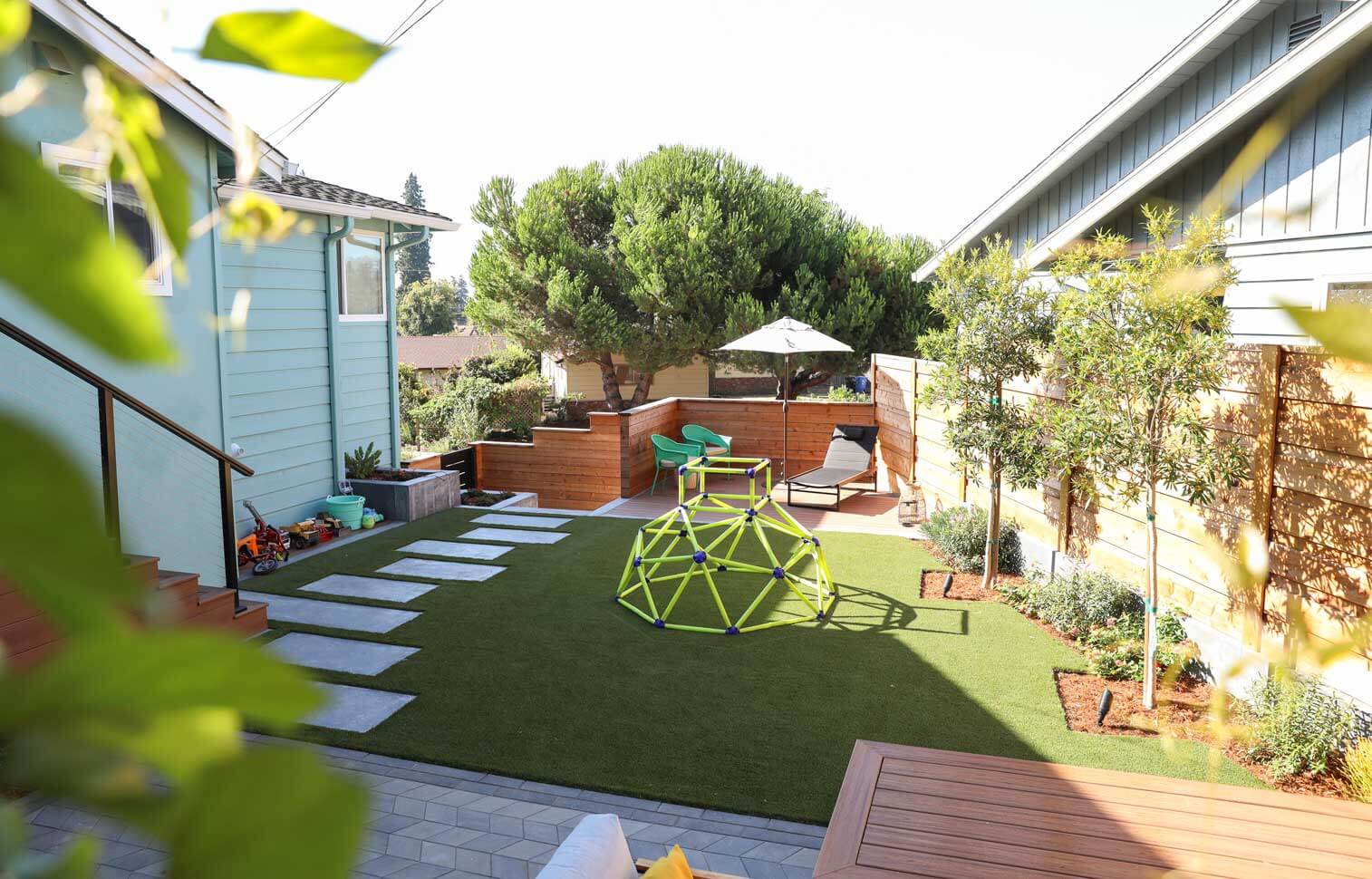 Contemporary backyard retreat with fire feature, planting, and hardscape elements by K&D Landscaping