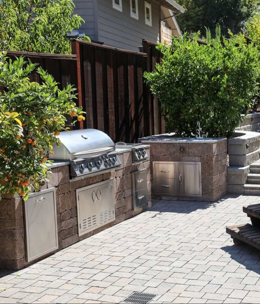 Backyard outdoor living space featuring fire pit seating area, natural stone patio, and landscape design by K&D Landscaping