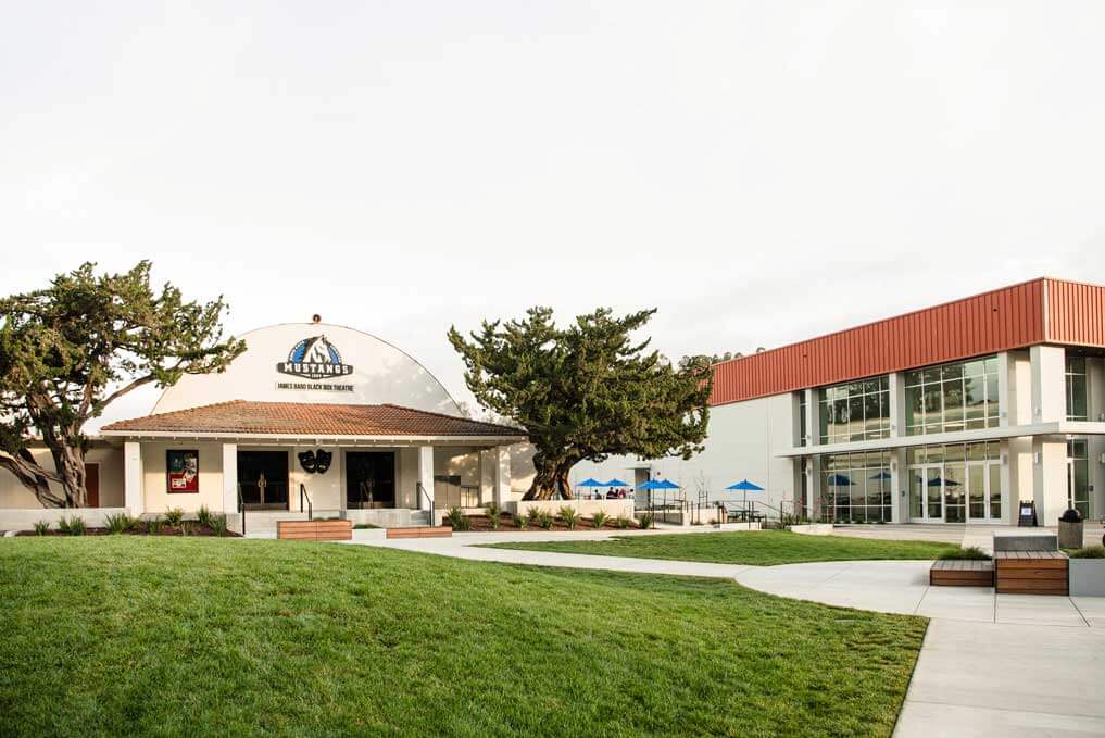 K&D Landscaping black box theatre and performing arts building beyond a sweeping lawn and walkways