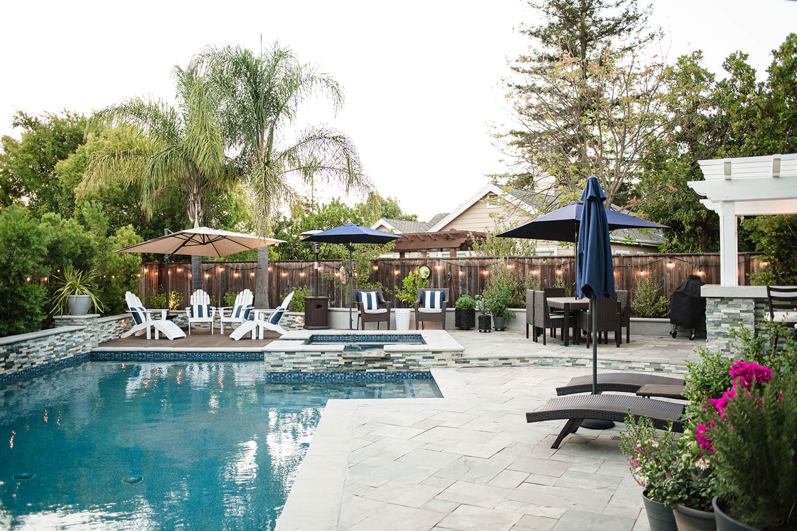 K&D Landscaping poolside water features integrated into custom retaining wall and landscape design