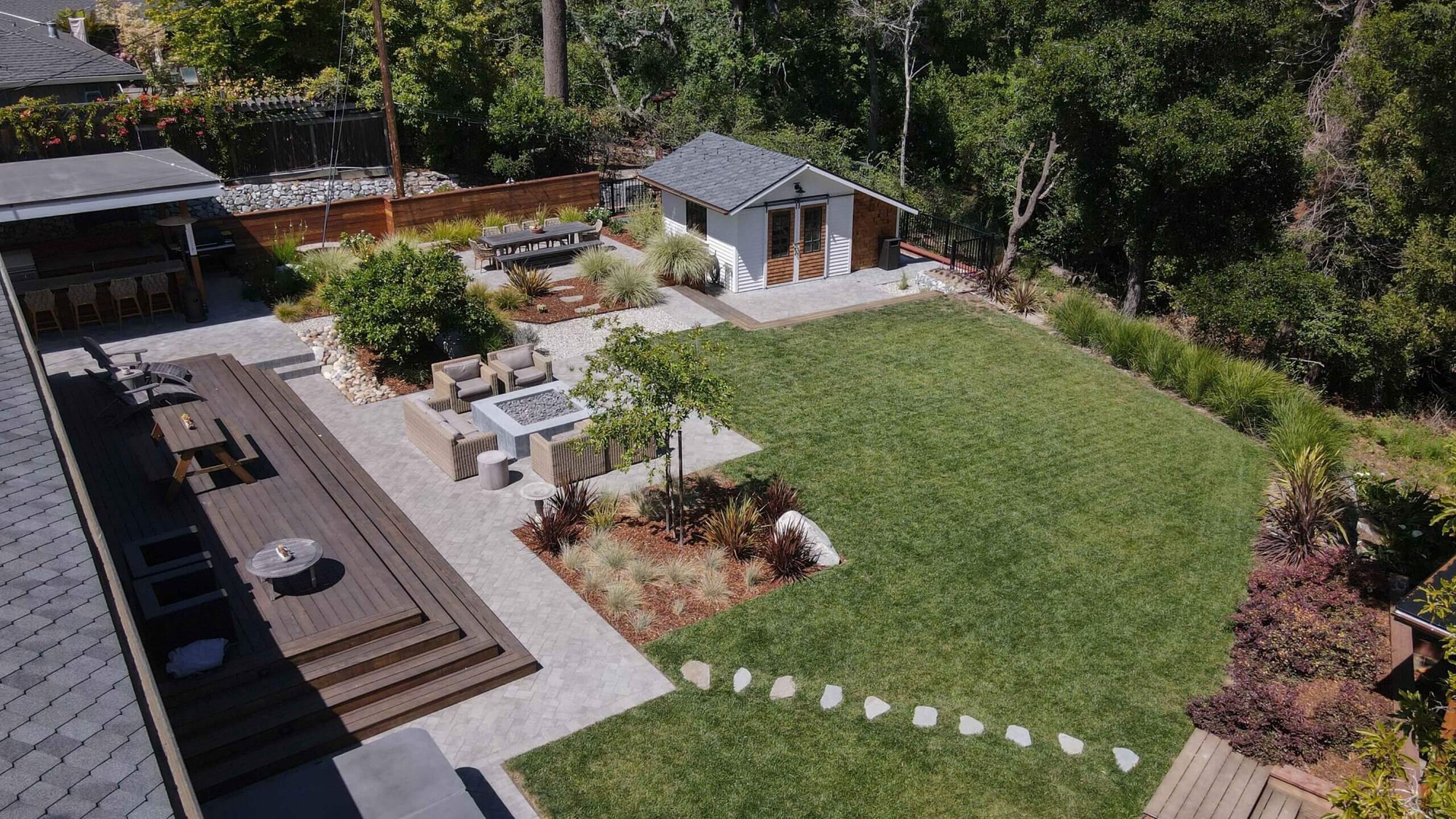 K&D Landscaping residential outdoor living project with paver patio, fire feature, lawn, and detached garden structure