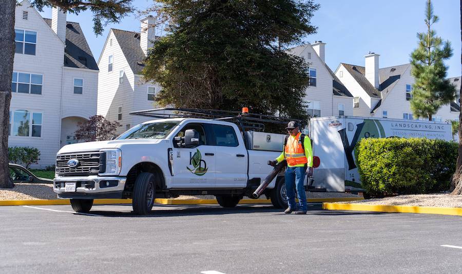 K&D Landscaping team member unloading equipment trailer for landscape maintenance services (1)