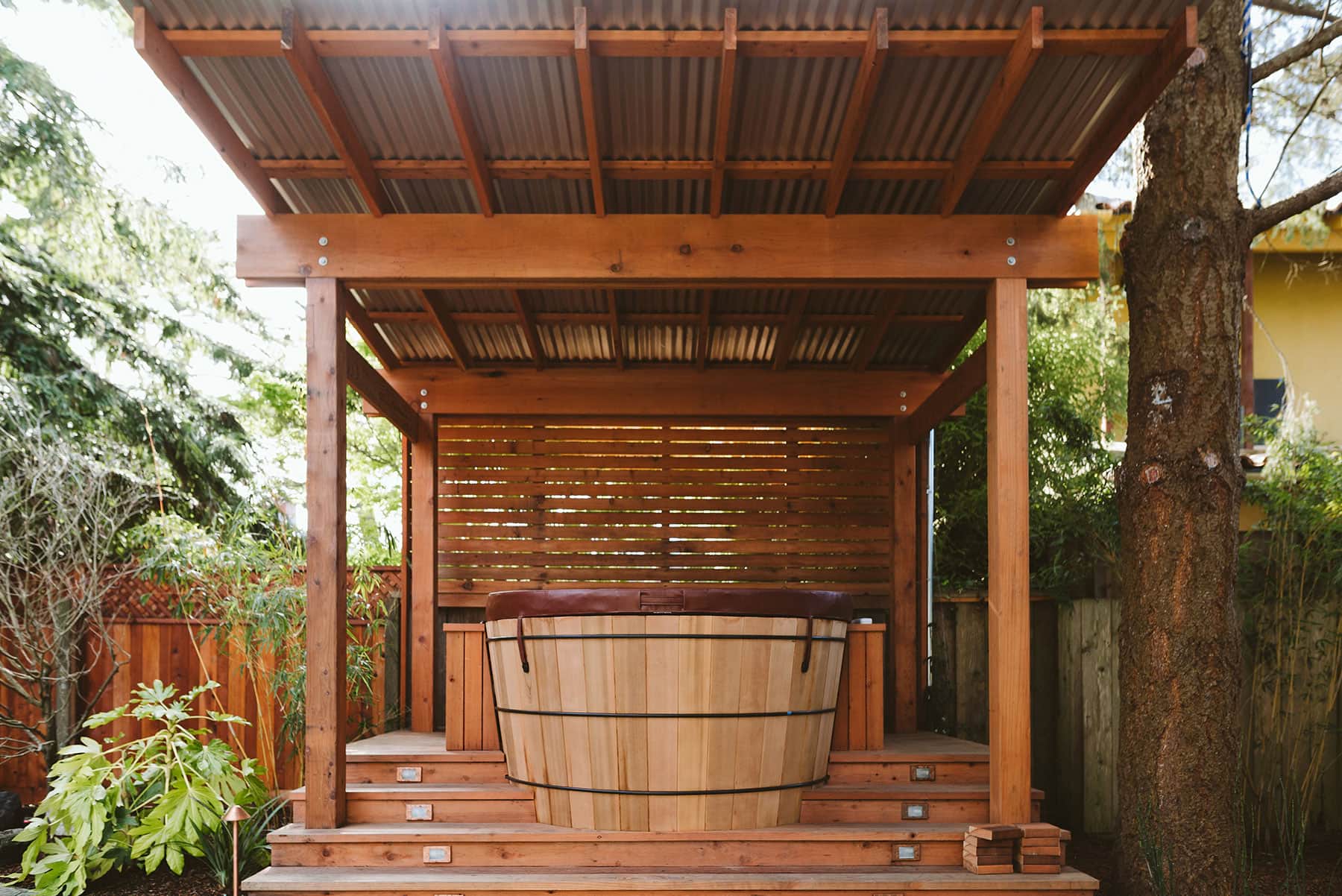 K&D Landscaping wooden pergola pergola structure with hot tub, slatted privacy walls, and deck platform