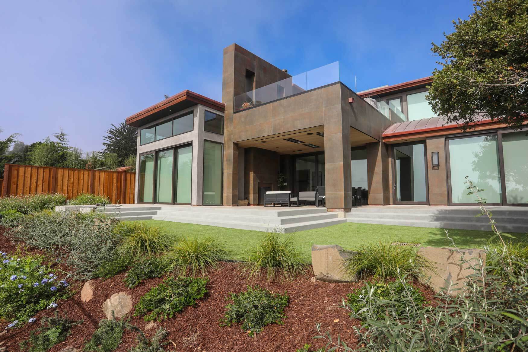 Modern residential landscape featuring concrete hardscapes and drought-tolerant plants by K&D Landscaping