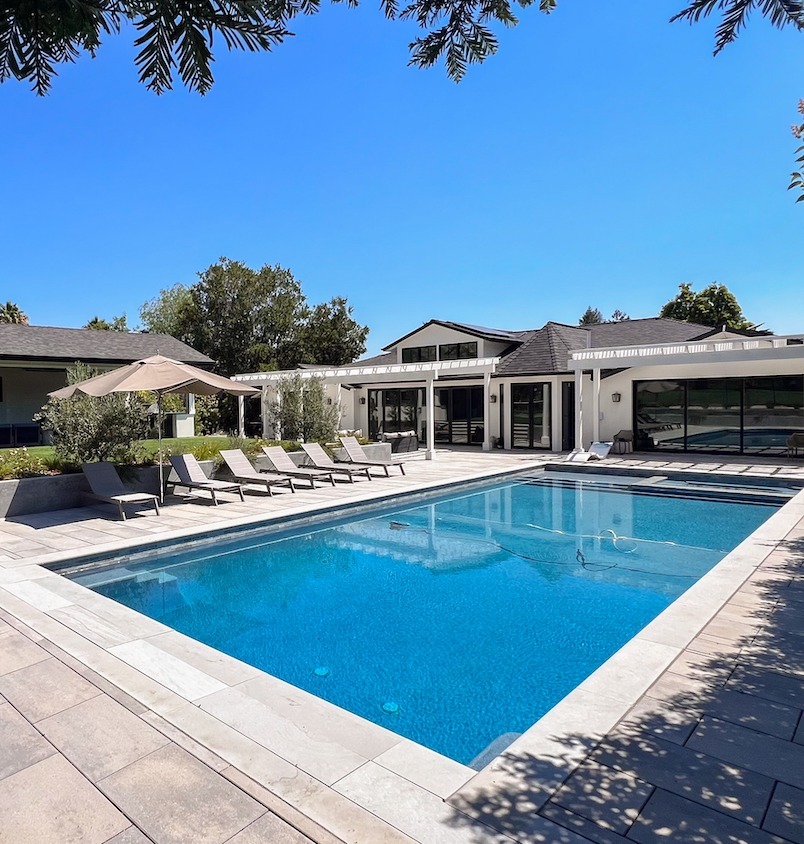 Residential backyard featuring pool, patio, and artificial lawn by K&D Landscaping