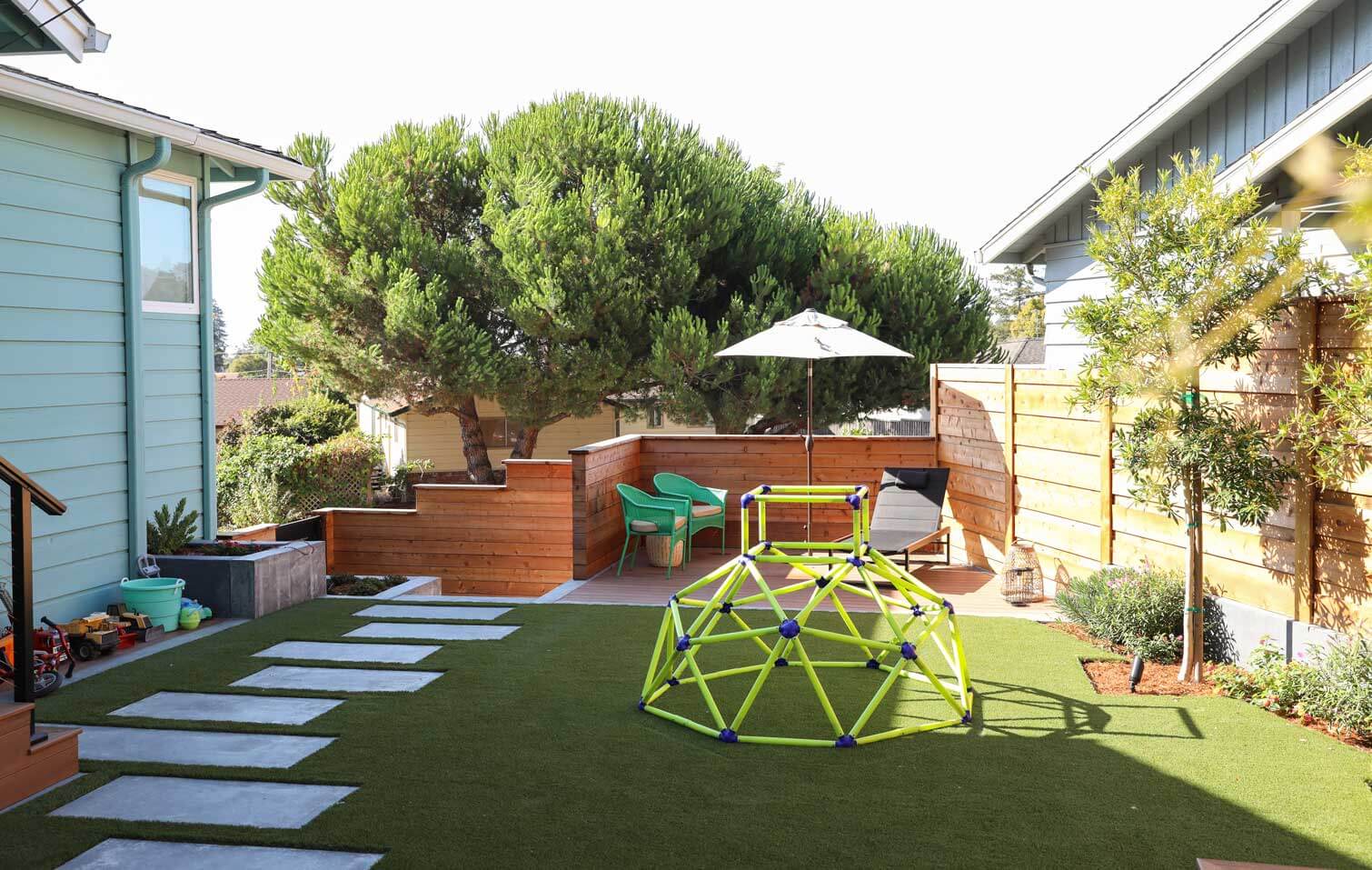 Aerial view of residential landscape featuring artificial turf, paver patio, and outdoor living spaces by K&D Landscaping