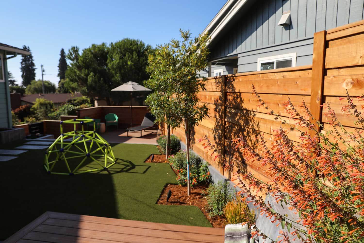 Artificial turf lawn and modern outdoor gathering area designed by K&D Landscaping