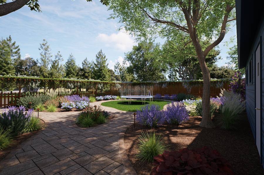 Backyard landscape design by K&D Landscaping featuring a curved paver walkway, colorful planting beds, mature trees, and a lawn with a trampoline
