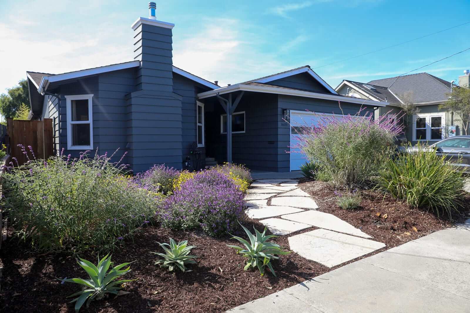Backyard landscape renovation featuring flagstone paths and outdoor living amenities by K&D Landscaping