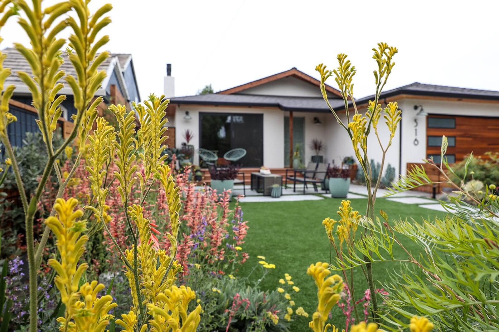 Backyard outdoor living space with fire pit and custom seating by K&D Landscaping