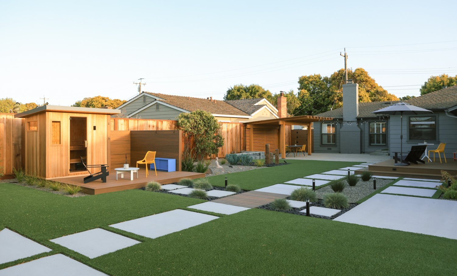 Backyard retreat with artificial lawn edible gardens and custom decking by K&D Landscaping