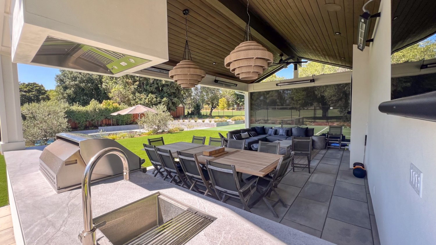 Backyard transformation connecting pool kitchen lawn and recreation spaces by K&D Landscaping