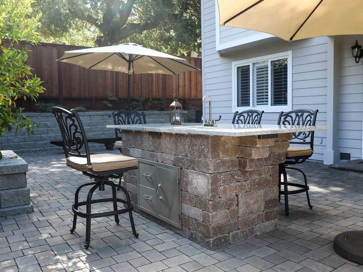 Backyard transformation with pavers, planters, and outdoor cooking space by K&D Landscaping