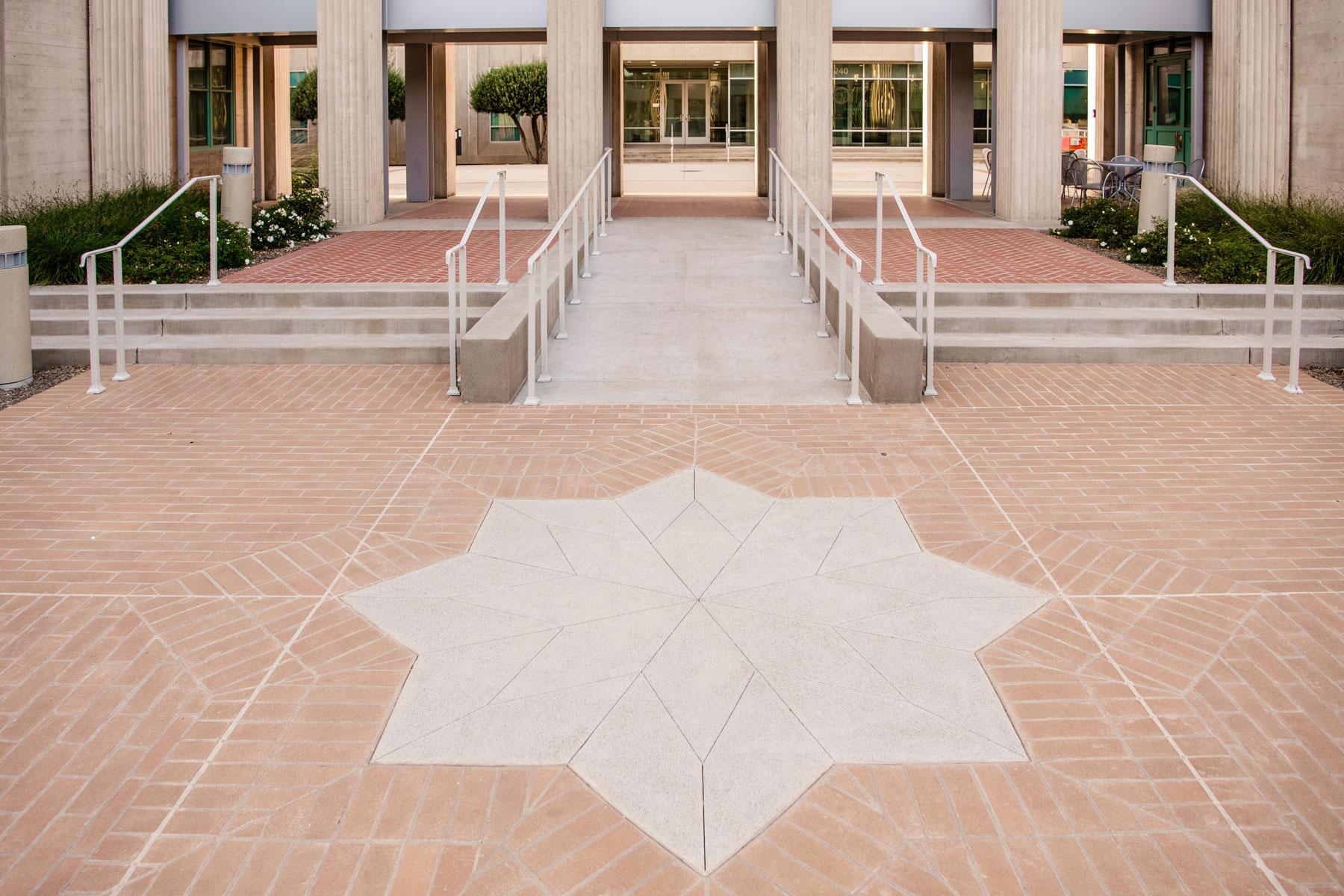 Central government building courtyard with symmetrical brick paving, raised planter, and landscape design by K&D Landscaping