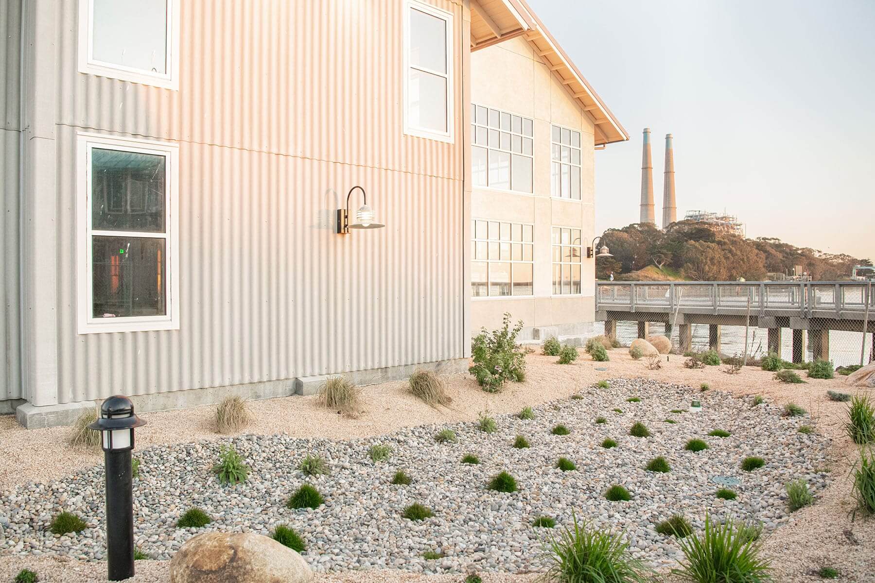 Commercial building exterior with drainage stone, landscape planting, and waterfront site improvements by K&D Landscaping