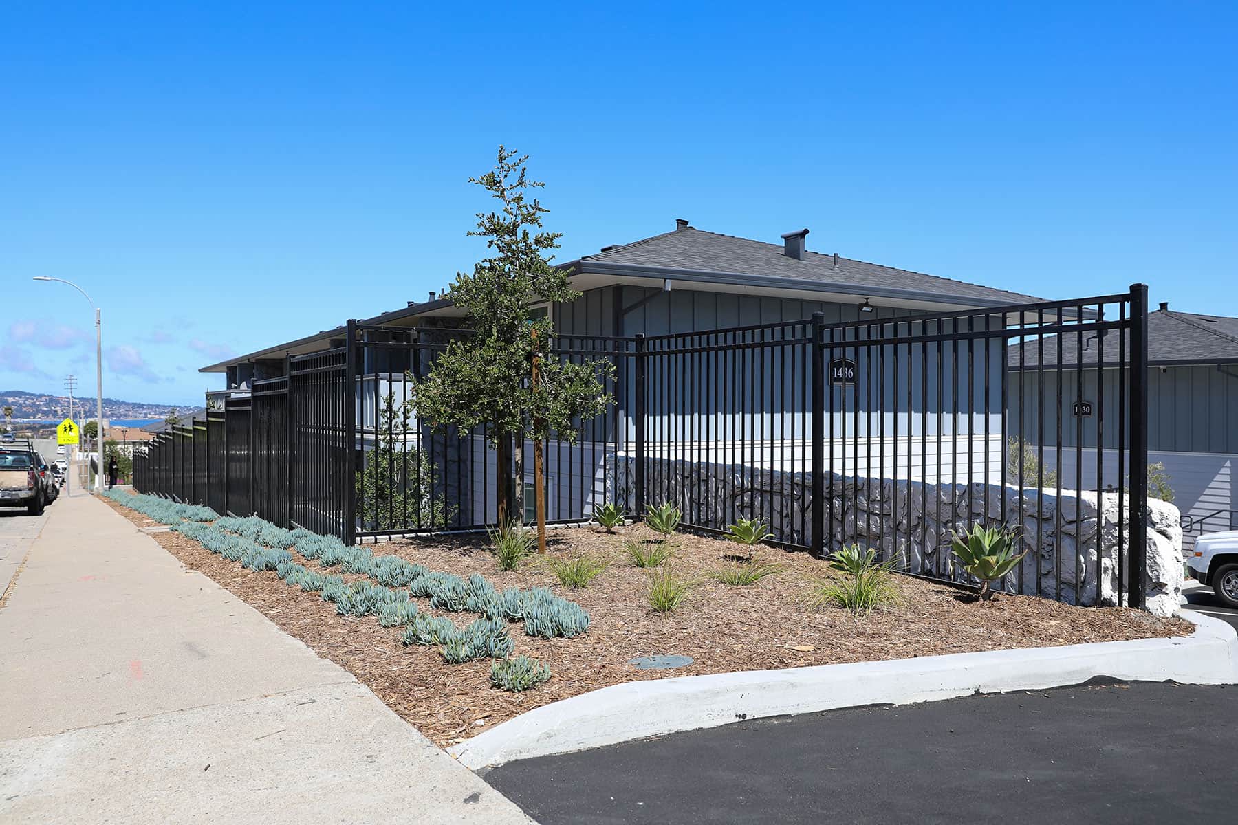 Commercial multifamily property featuring new landscape plantings and hardscape by K&D Landscaping