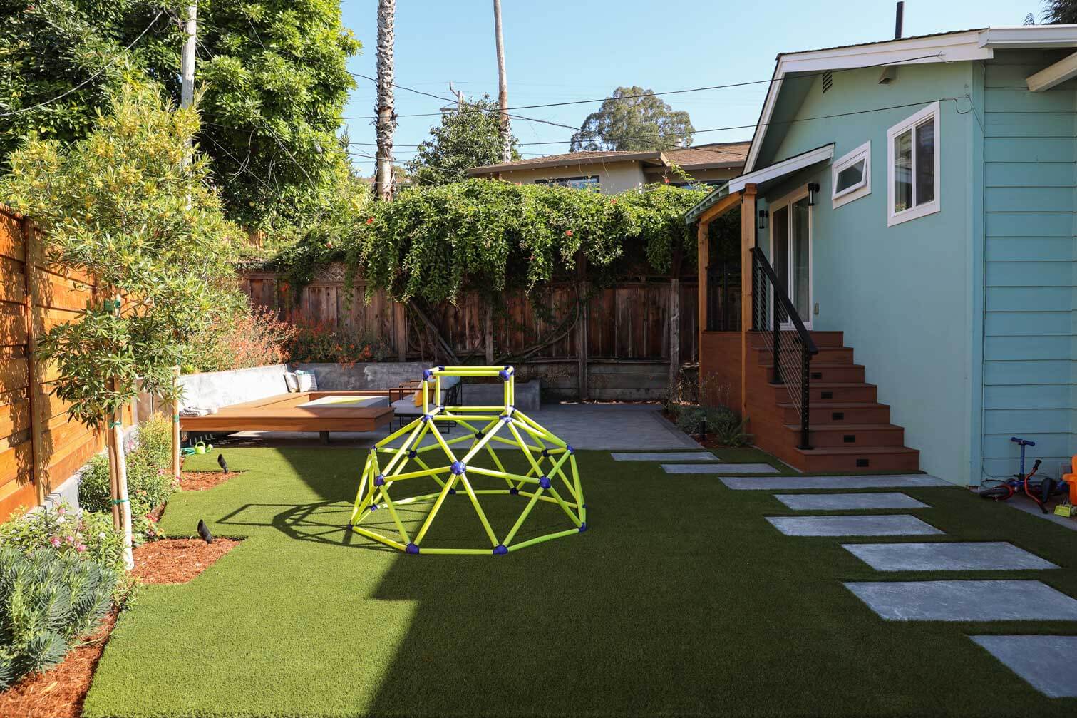 Composite deck and outdoor dining space integrated into a custom backyard design by K&D Landscaping