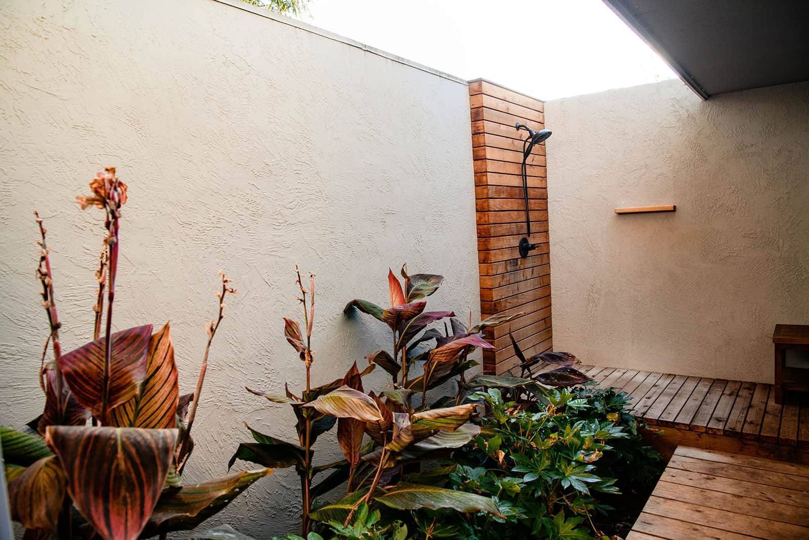 Courtyard landscape with stucco walls, wooden trellis, colorful foliage plantings, and interior garden design by K&D Landscaping