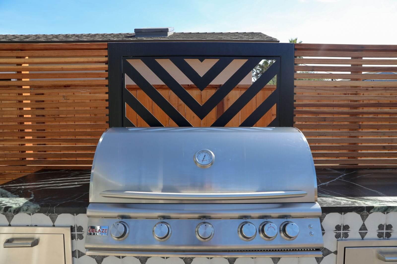 Custom fire pit surrounded by professionally designed landscape features by K&D Landscaping