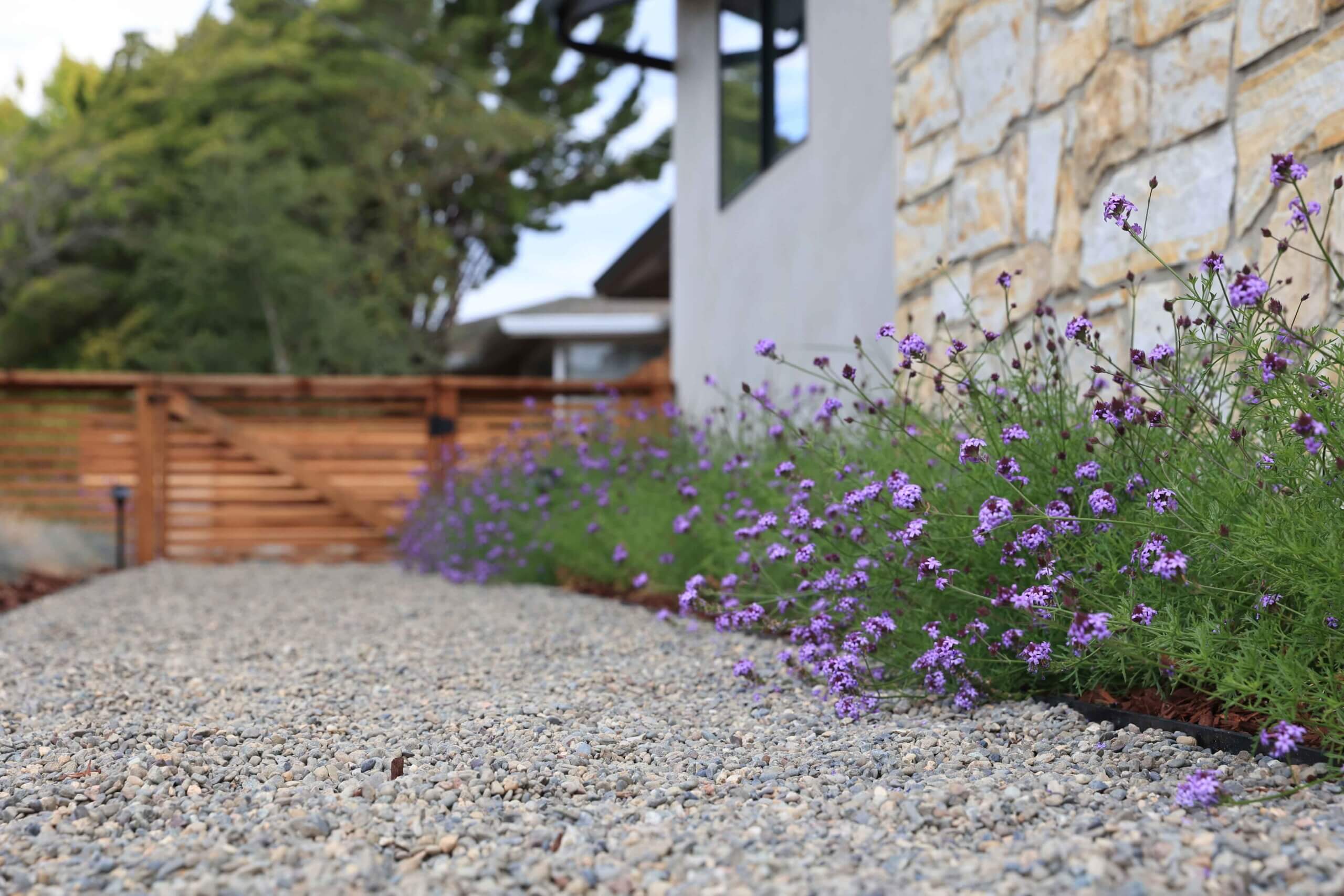Custom residential landscape featuring decorative pathways and planting beds by K&D Landscaping