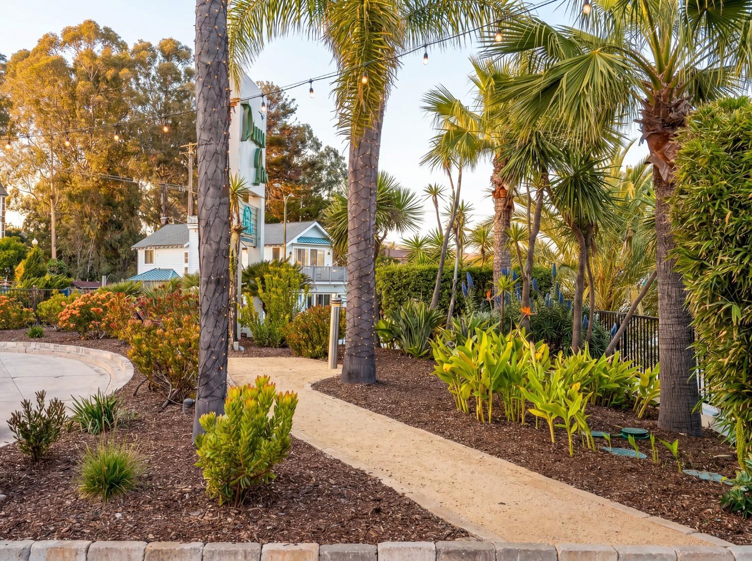 Evening view of landscaped hospitality property with decorative lighting maintained by K&D Landscaping