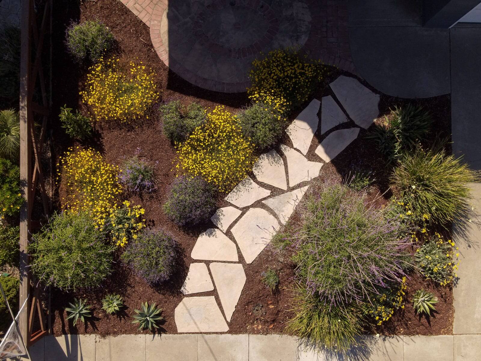 Flagstone garden pathway winding through colorful residential landscape plantings by K&D Landscaping