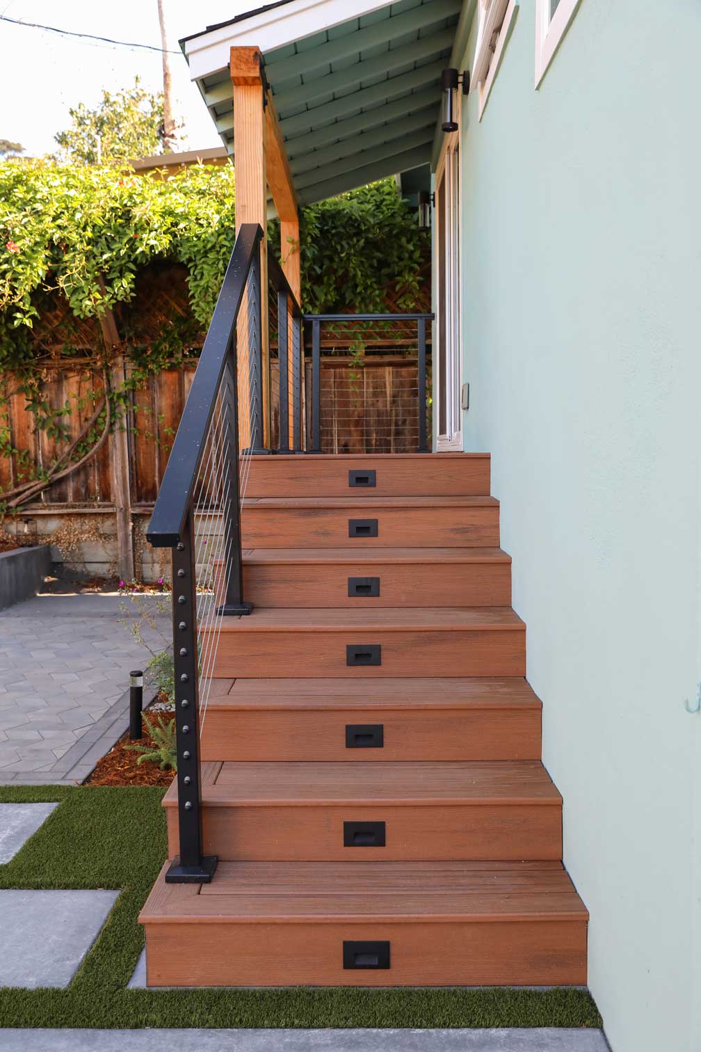 Floating composite bench with concrete backrest and contemporary landscape design by K&D Landscaping