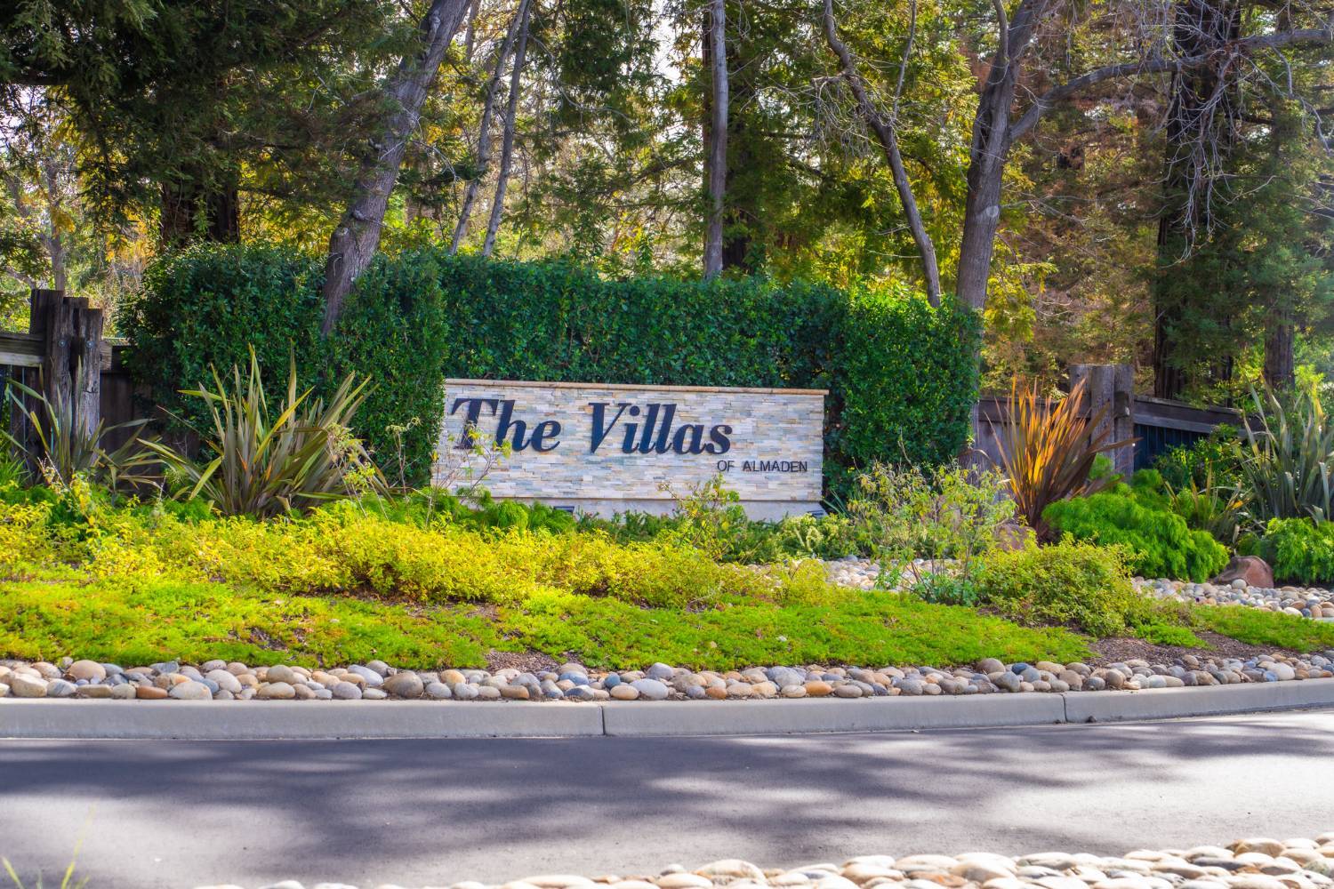 HOA entrance landscape maintained by K&D Landscaping with layered plantings and healthy turf