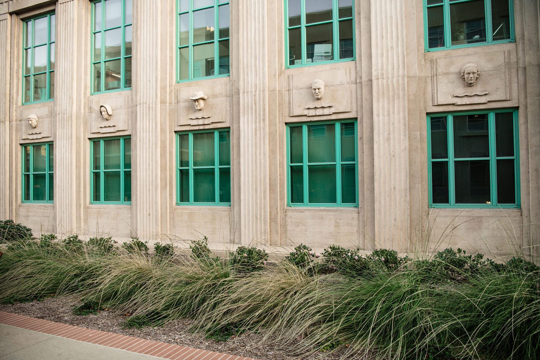 Historic government building exterior with architectural stonework, metal-frame windows, and extensive drought-tolerant grass landscaping by K&D Landscaping