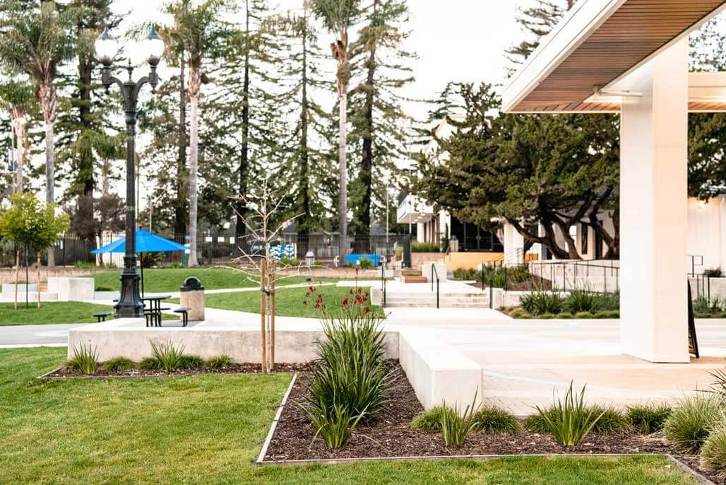 K&D Landscaping campus quad with picnic tables, ornamental beds and a classic lamppost
