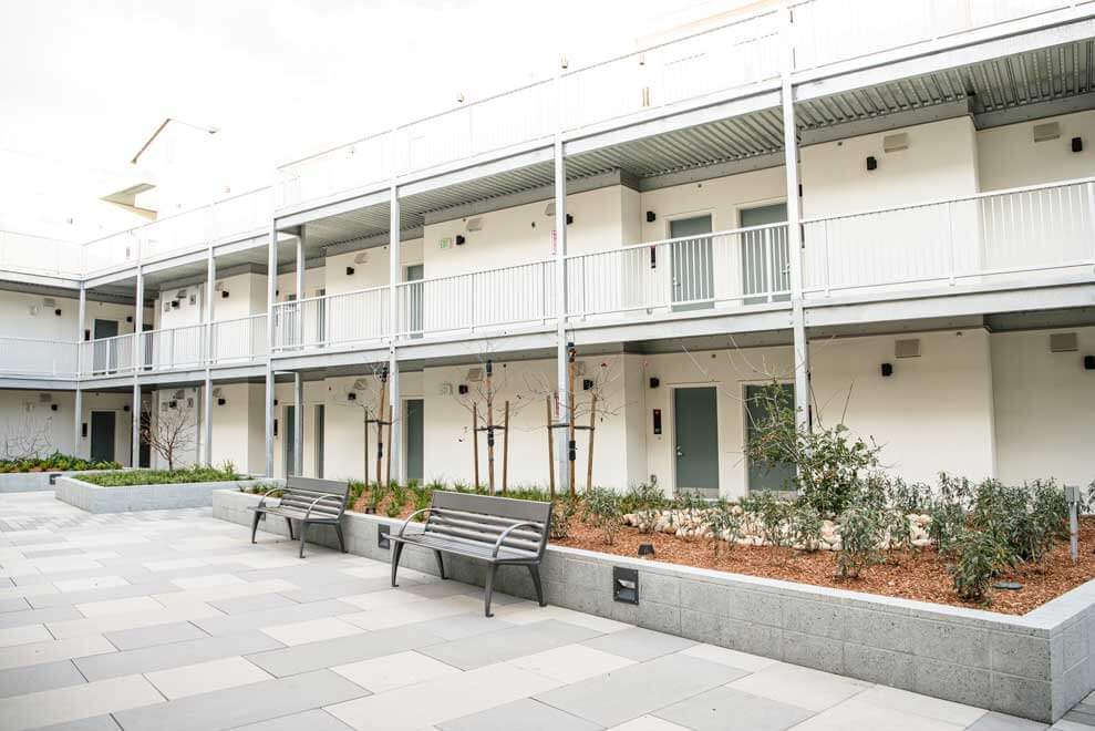 K&D Landscaping community courtyard seating area with raised planters and landscape enhancements