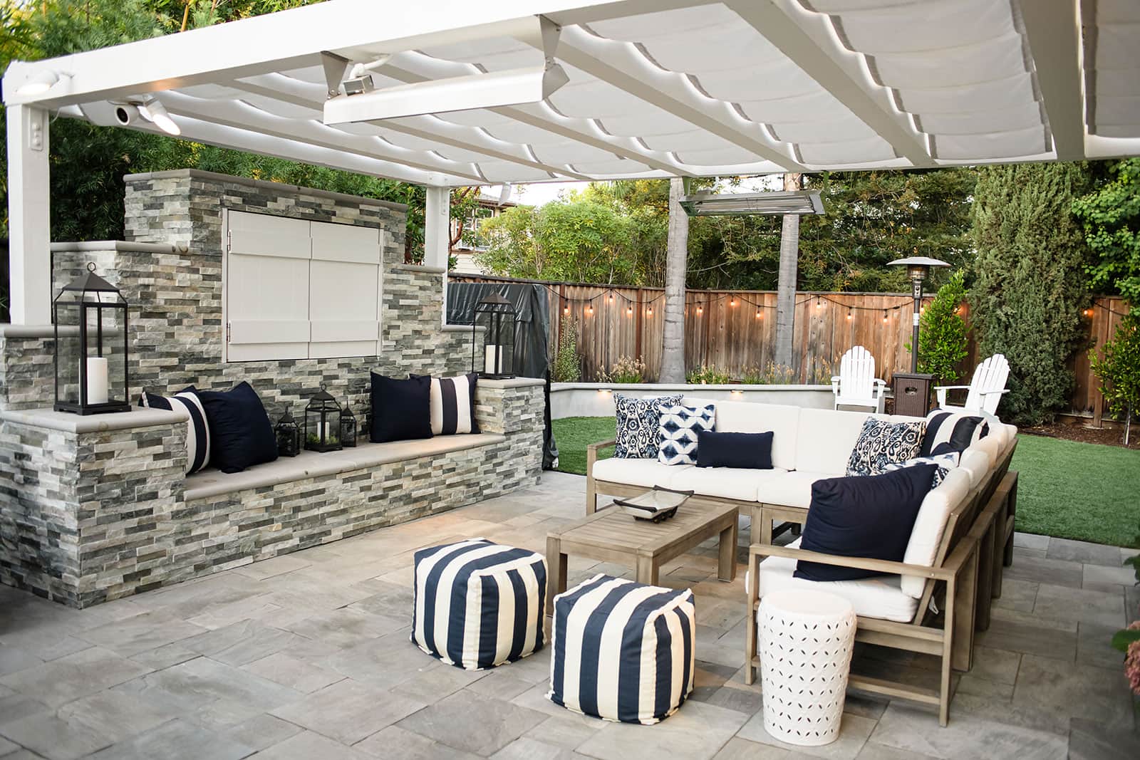 K&D Landscaping covered outdoor living room with custom seating wall and entertainment area
