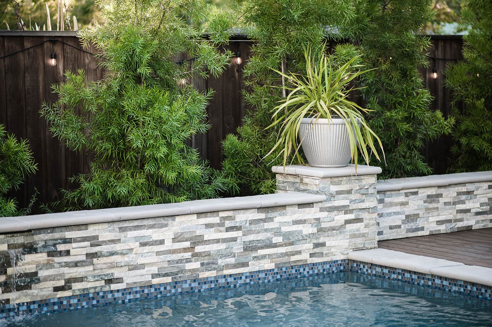 K&D Landscaping custom pool and patio design with outdoor dining and resort-style amenities