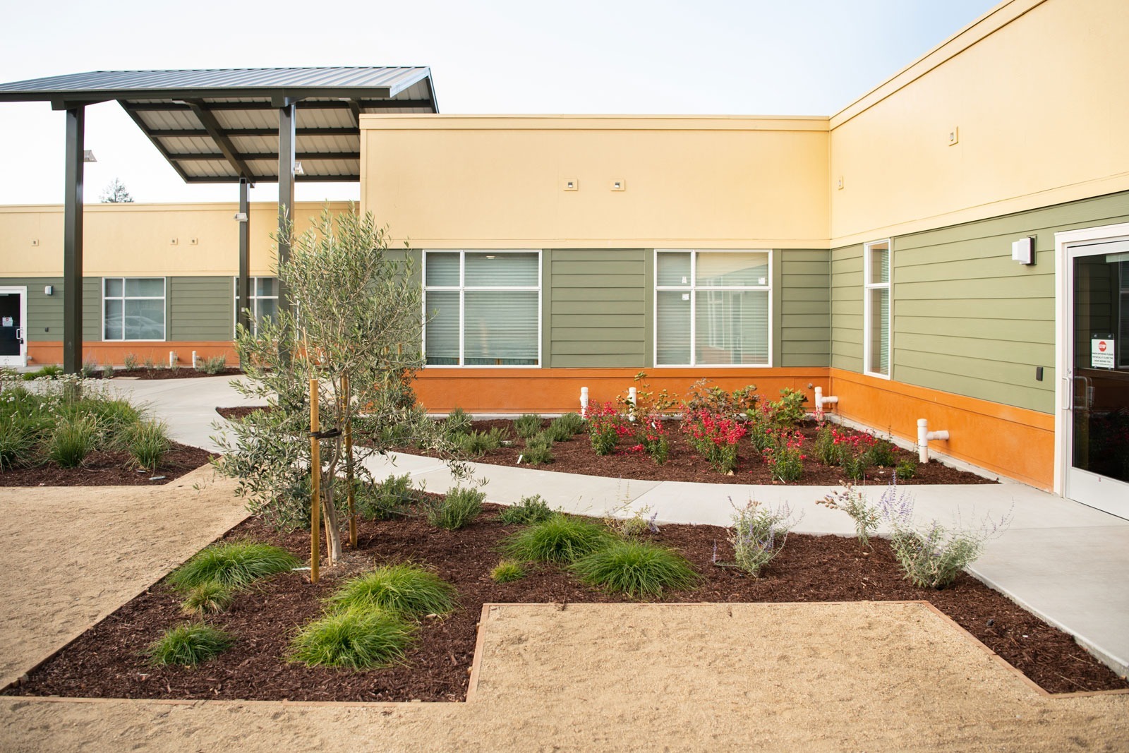 K&D Landscaping landscape construction with concrete pathway and mulched planting areas surrounding healthcare facility
