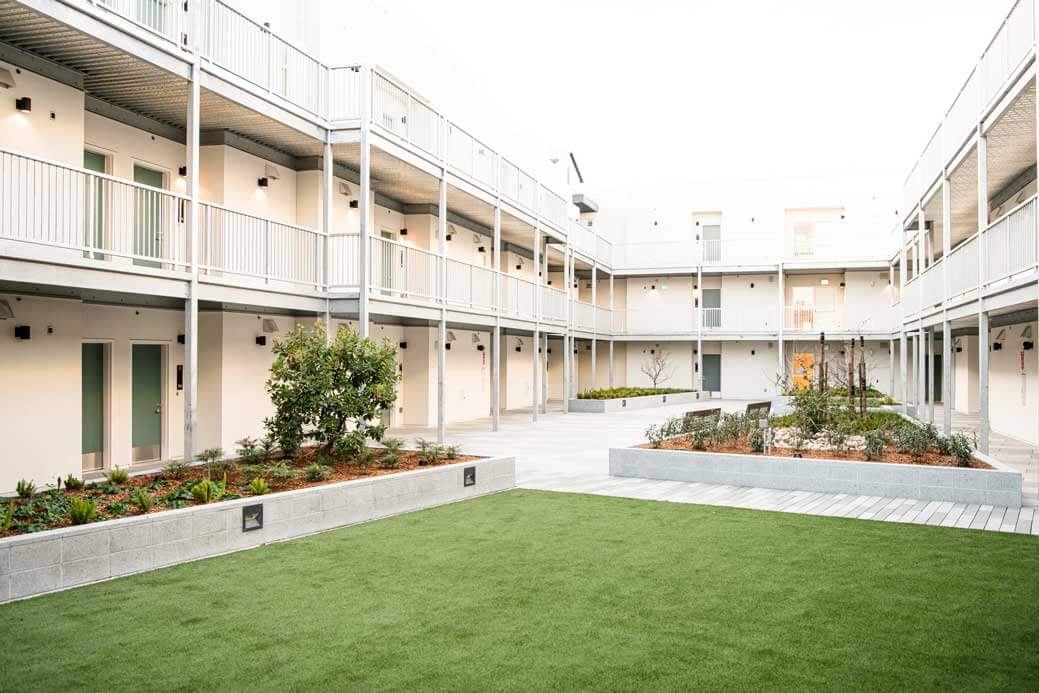 K&D Landscaping landscaped apartment courtyard with synthetic turf and raised planters