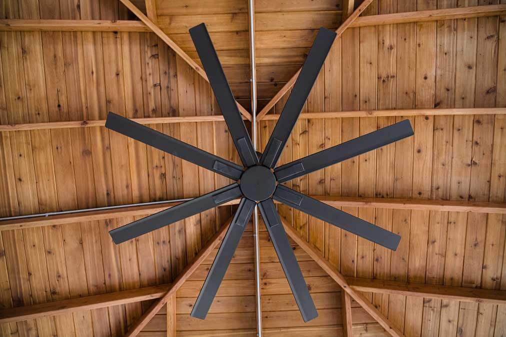 K&D Landscaping large black ceiling fan mounted on a cedar-clad pavilion ceiling