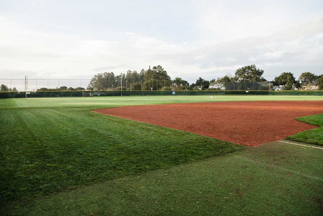 K&D Landscaping manicured baseball infield with a skinned clay diamond and striped turf edges