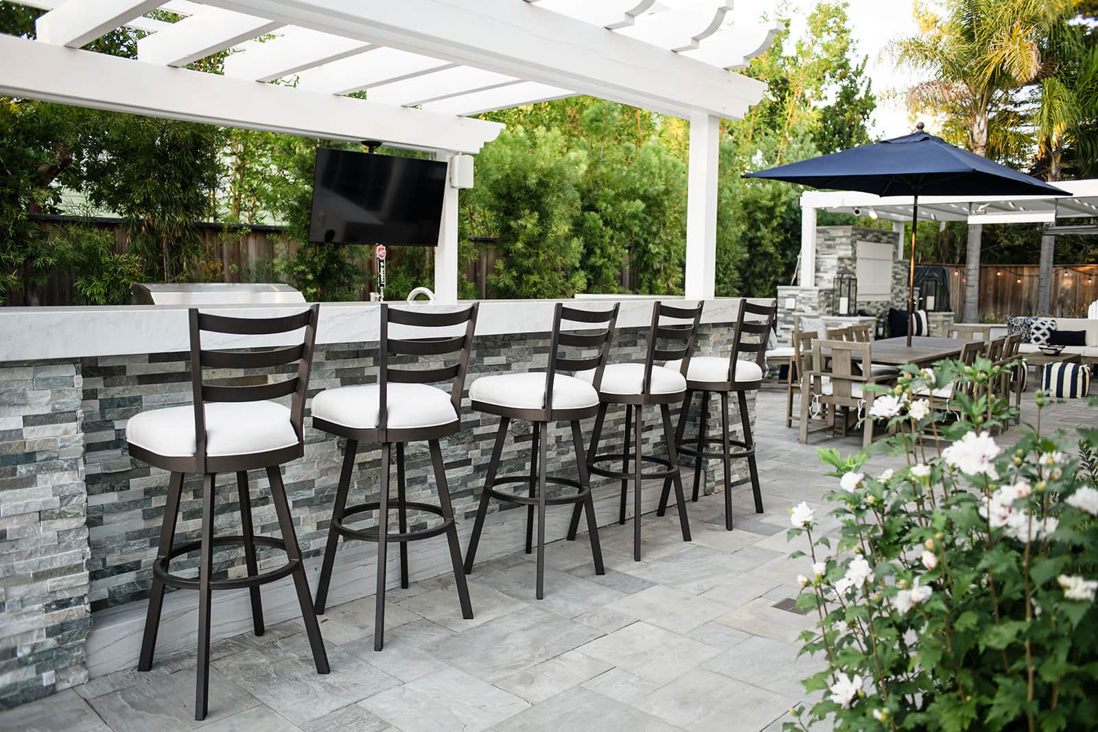 K&D Landscaping outdoor kitchen with granite countertops, built-in appliances, and bar seating