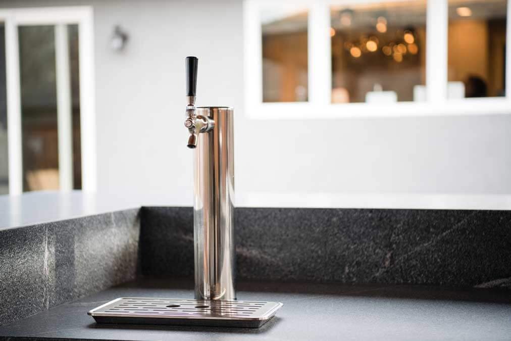 K&D Landscaping stainless beer tap tower on a honed granite outdoor bar counter
