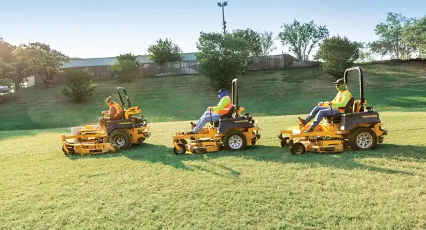 Landscaping crew member mowing a property