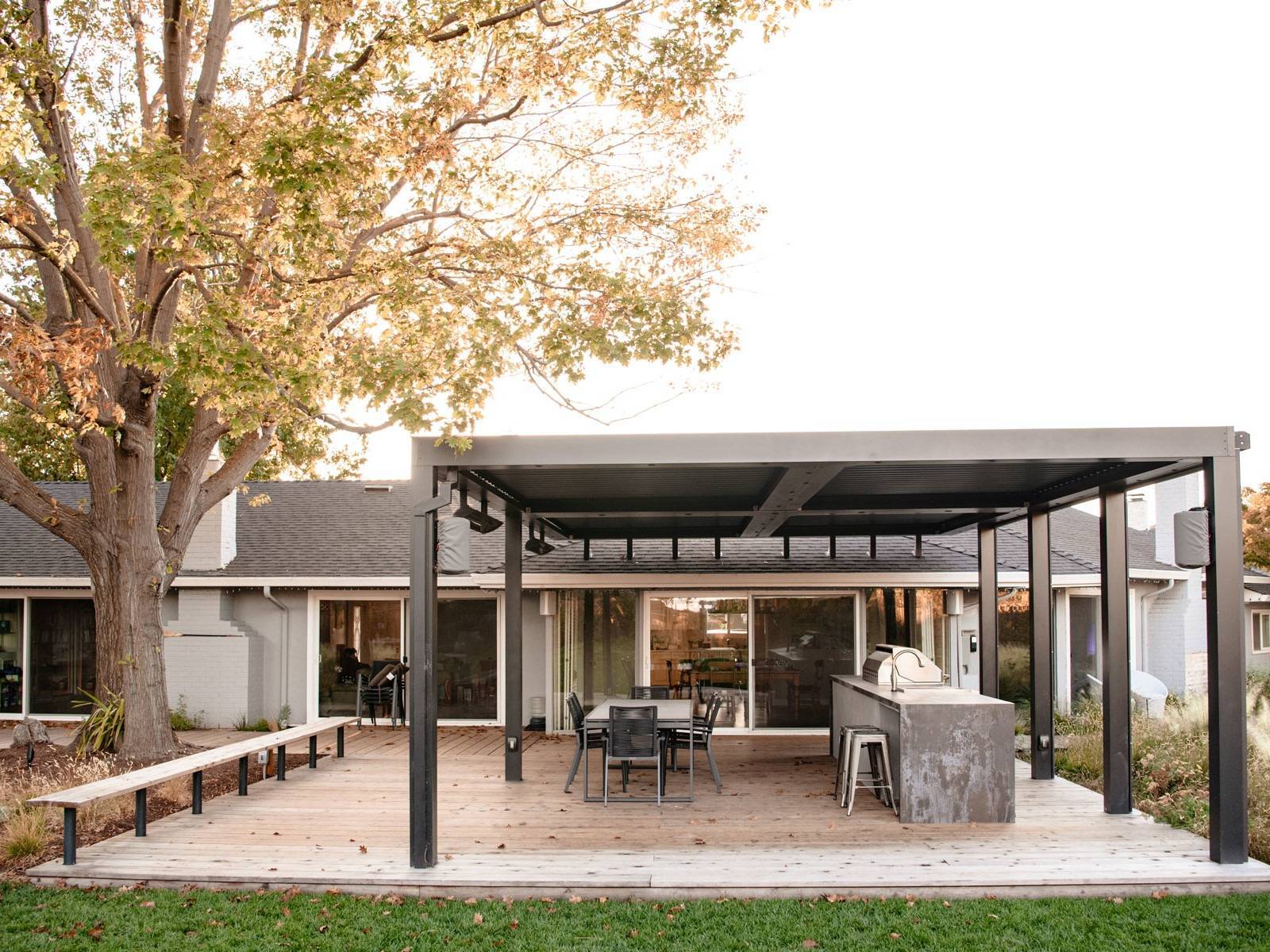 Landscape design featuring fire pit entertaining area with stone patio, cushioned seating, and mixed plantings by K&D Landscaping