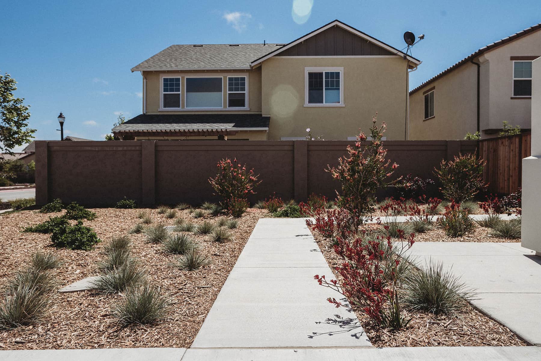 Modern dark fence, drought-tolerant planting, and gravel landscape completed by K&D Landscaping