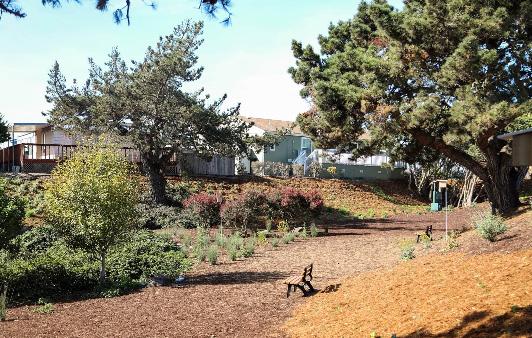 Mulched planting beds improving a residential community park by K&D Landscaping