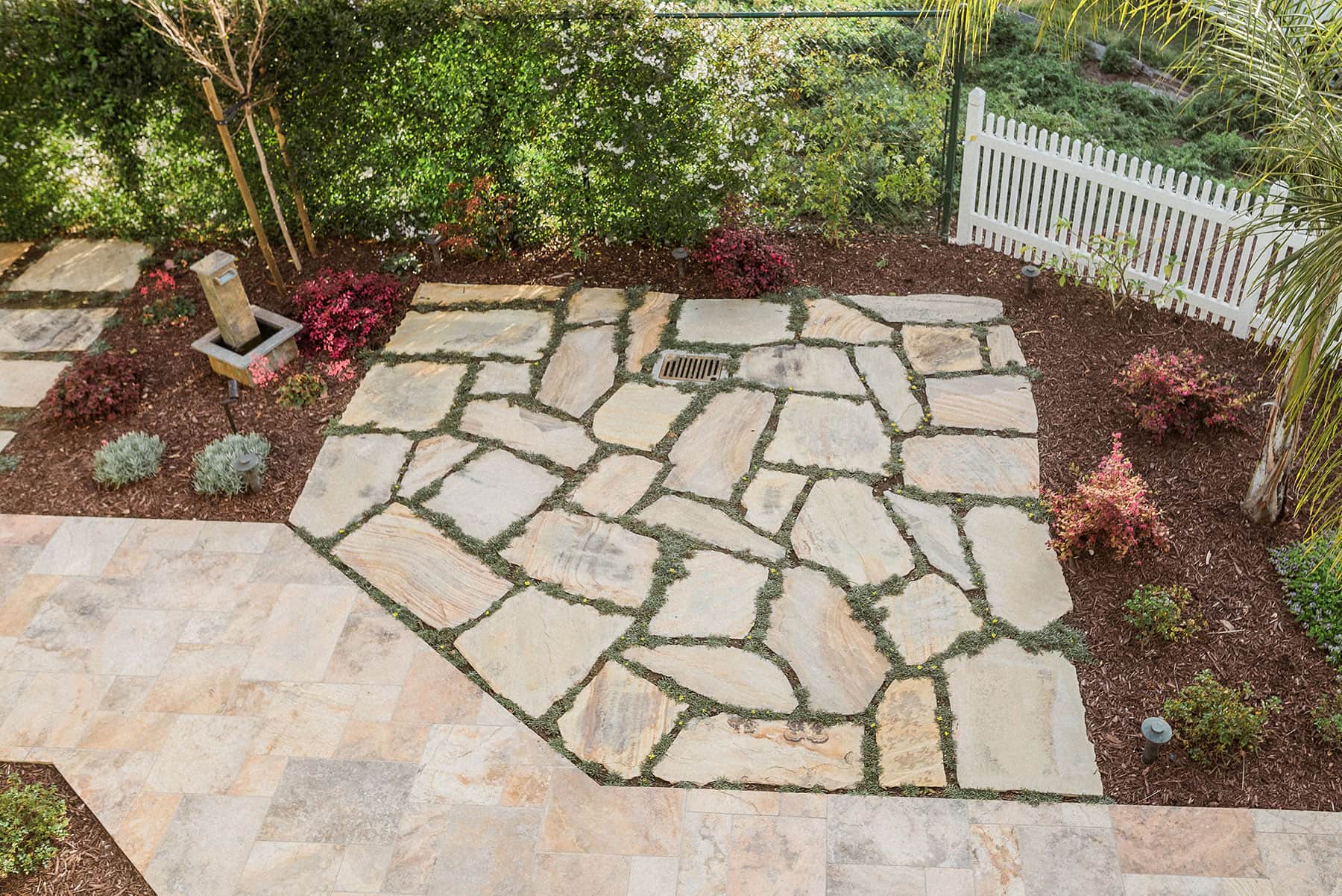 Natural flagstone patio with grass, perennials & landscape lighting installed by K&D Landscaping