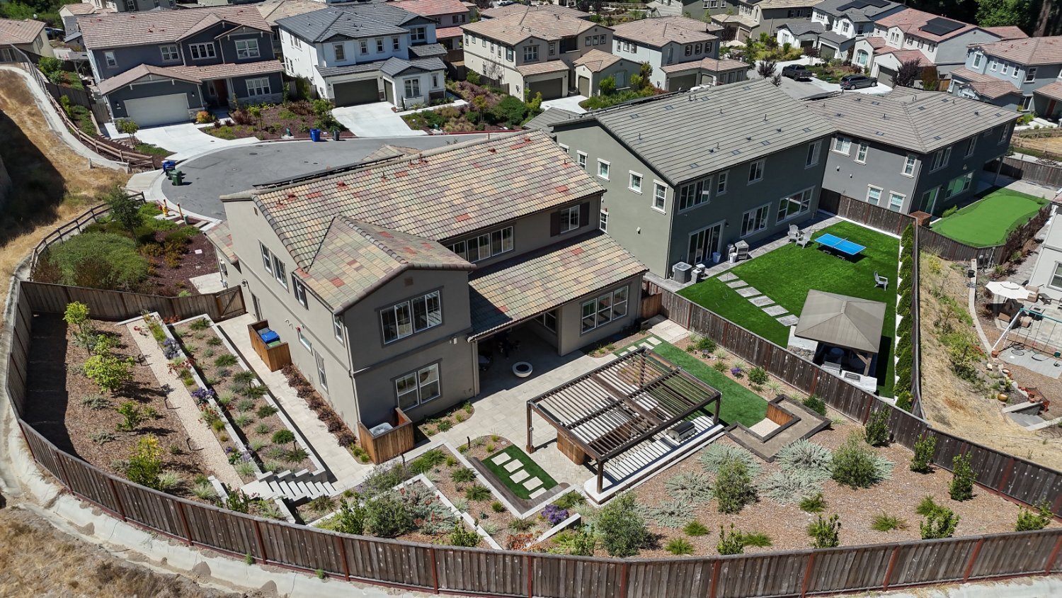 Outdoor gathering space featuring pergola and custom hardscape by K&D Landscaping