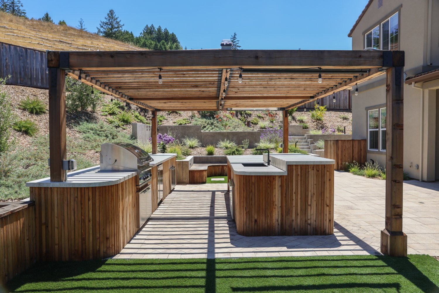 Outdoor living area designed around drainage and grade challenges by K&D Landscaping