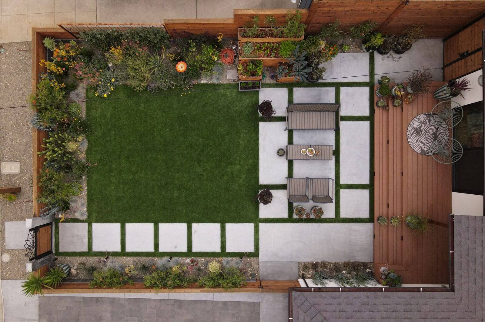 Overhead view of outdoor living space featuring a pergola, custom concrete seating, lawn, and stepping stone pathways by K&D Landscaping