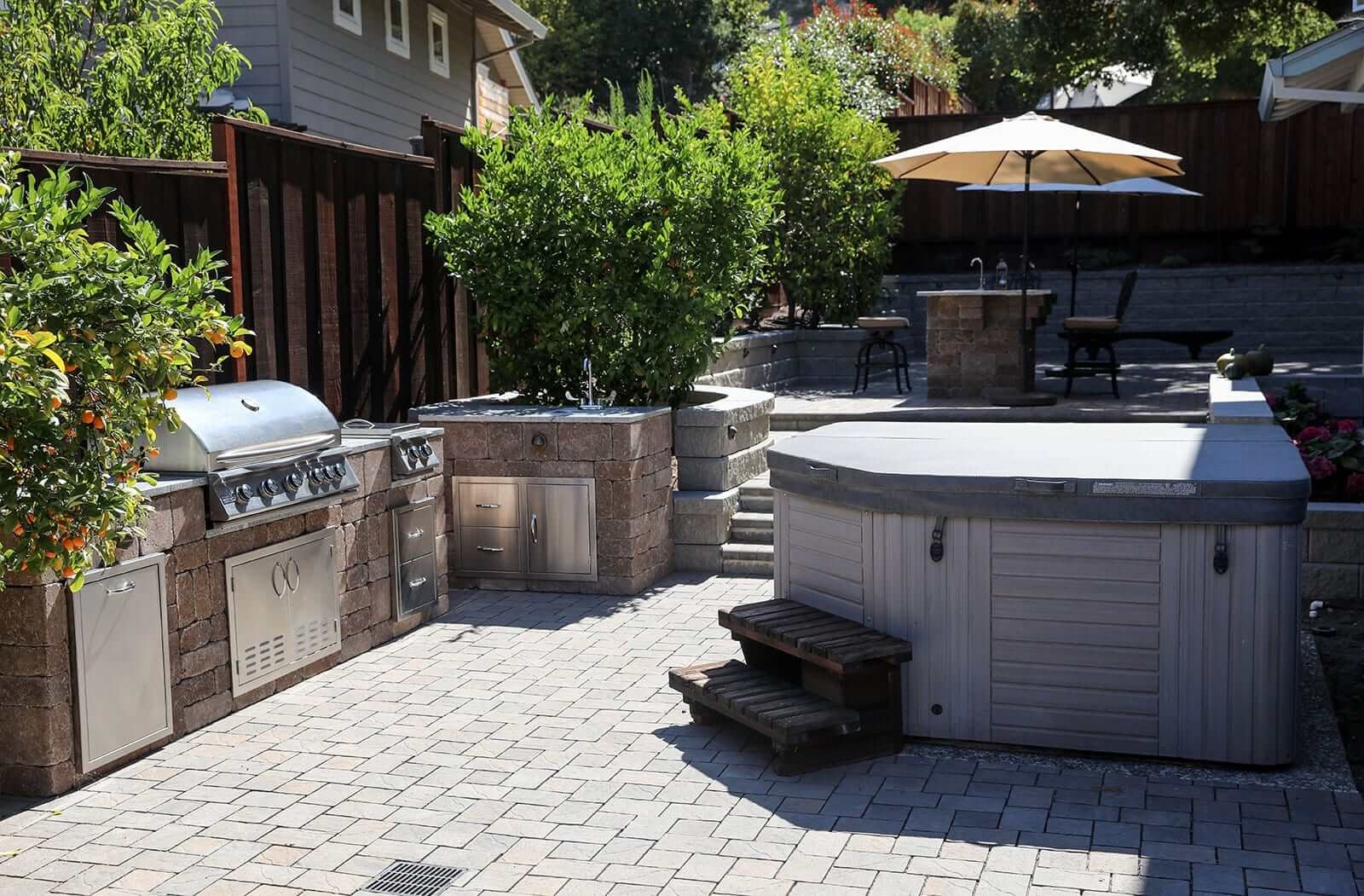 Paver patio and outdoor kitchen designed for backyard entertaining by K&D Landscaping